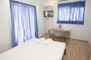 pokój z dwoma łóżkami, stołem i biurkiem w obiekcie Lovely Studio With Amazing Terrace w Atenach