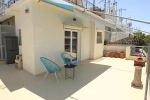 taras z dwoma krzesłami i stołem w obiekcie Lovely Studio With Amazing Terrace w Atenach