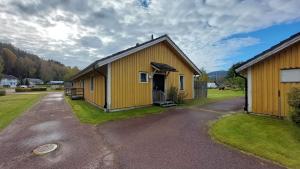 a yellow building with a driveway in front of it at 4 Bed apartment close to Branäs - Likemovägen 11C in Likenäs