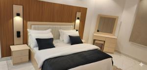 a bedroom with a large bed and two mirrors at شقق الفخامة in Al Madinah