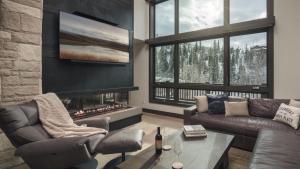 a living room with a couch and a fireplace at Orion Lodge in Steamboat Springs