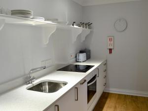 a white kitchen with a sink and a counter at Buzzards - 8235 in Bridport