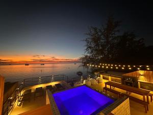 una piscina en la terraza de una casa por la noche en Sairee Beach Penthouse, en Ko Tao