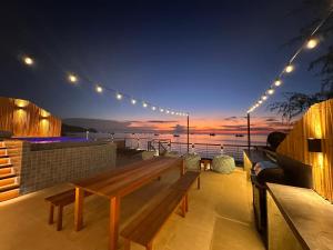 un banco de madera en una terraza con vistas al océano en Sairee Beach Penthouse, en Ko Tao 42 fotos más