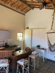 a kitchen with a stove and a table and chairs at House in Arraial do Cabo in Arraial do Cabo