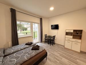 a bedroom with a bed and a kitchen with a window at Mira Nest - Budapest City in Budapest