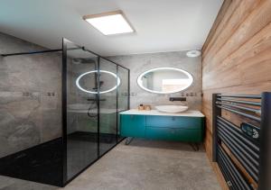 Un baño con ducha de cristal y lavabo. en Chalet Le Refuge Luxe Authenticité Serre Chevalier, en La Salle-les-Alpes 30 fotos más