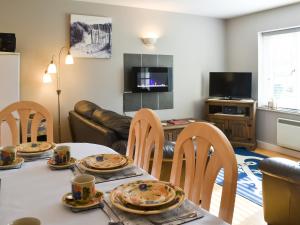 un salon avec une table, des chaises et un canapé dans l'établissement 15 Pebble Cottage, à Camelford