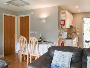 un salon avec un canapé, une table et des chaises dans l'établissement 15 Pebble Cottage, à Camelford