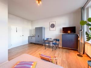 a living room with a table and a tv at Studios am Hafen in Stralsund