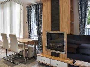 PrentegにあるOaks Retreatのリビングルーム(ダイニングテーブル、テレビ付)