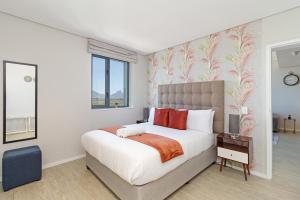 a bedroom with a large bed with red pillows at 2 Bed Executive Apartment Table Mountain views in Cape Town +21 photos