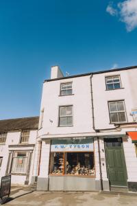 a white building with a green door on a street at Tyson Place, 2 bed Renovated Apartment, Ambleside in Ambleside