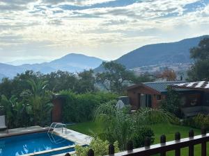 een huis met een zwembad en bergen op de achtergrond bij Ochi Houses - Ain drahem in Ain Draham