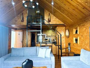 een woonkamer met een bank en een wenteltrap bij Ochi Houses - Ain drahem in Ain Draham