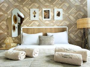 een slaapkamer met een groot wit bed met foto's aan de muur bij Ochi Houses - Ain drahem in Ain Draham