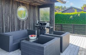 a outdoor patio with two chairs and a grill at Cozy Home In Bjönni With Sauna in Ellös +14 photos