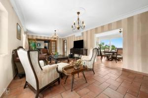 ein Wohnzimmer mit Sofa, Stühlen und einem Tisch in der Unterkunft Villa Casa Beatriz in Palmela in Palmela