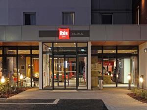 una tienda frente a un edificio con un cartel de alta en Ibis Saint-Genis-Pouilly Genève, en Saint-Genis-Pouilly