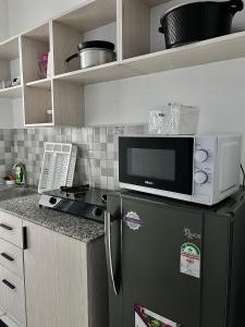 a kitchen with a microwave on top of a refrigerator at Lavish 2 Bedroom in Mombasa CBD in Mombasa