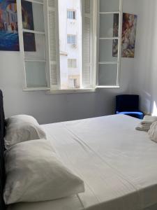 チュニスにあるLafayette Central Apartmentの白いベッド(枕2つ付)、窓2つが備わります。