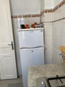 チュニスにあるLafayette Central Apartmentの小さなキッチン(白い冷蔵庫付)が備わる客室です。