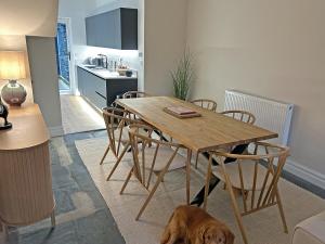 ein Hund auf dem Boden neben einem Esstisch in der Unterkunft Ivy Cottage in Staveley