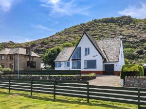 a white house with a hill in the background at Gleaner Lea Apartment in Campbeltown