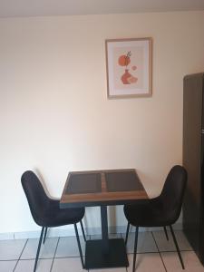 a wooden table with two black chairs and a table at La douce Parenthèse in Namur