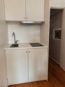 eine Küche mit weißen Schränken und einer Spüle in der Unterkunft Panorama Apartments Ribeira Porto in Porto