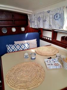 a table with plates and cups on top of it at Romantic getaway on a sailboat in the Tagus in Lisbon