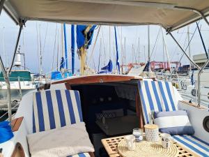 a boat with two chairs and a table on it at Romantic getaway on a sailboat in the Tagus in Lisbon +11 photos