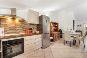 a kitchen with a stainless steel refrigerator and a table at Mayor's House in Iglesias