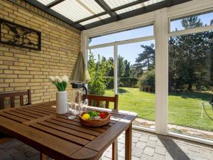 a wooden table with a basket of fruit on a patio at Holiday Home Johanna - 400m from the sea by Interhome in Dannemare +16 photos