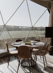 a table and chairs in a room with a window at Luxury Star Gazing Dome 3 NEPTUNE with Cozy log burner in Horspath