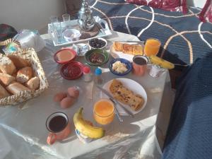a table with breakfast foods and drinks on it at Adar surf house in Taghazout +29 photos