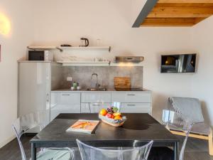 a kitchen with a table with a bowl of fruit on it at Apartment Camping Turisport-3 by Interhome in Dervio +22 photos