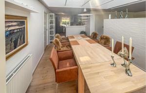 a dining room with a long wooden table and chairs at Nice Home In Esbjerg V With Wifi in Ådal