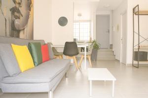 ein Wohnzimmer mit einem grauen Sofa und bunten Kissen in der Unterkunft Ola Azul Bungalow in Benidorm