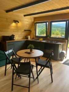a kitchen with a table and chairs in a room at Brda 5 osobowa z jacuzzi in Zawoja