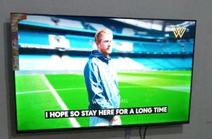 a television screen with a picture of a soccer game at Royalcarevillas in Thika +2 photos