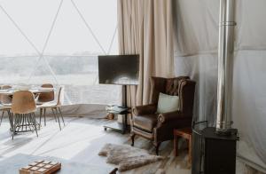 a living room with a chair and a table at Star Gazing Dome 2 with Log Burner & Optional Hot tub in Horspath