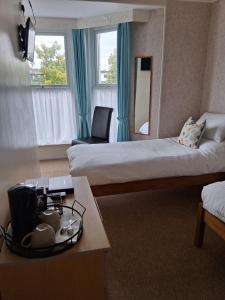 a hotel room with two beds and a table at Barbican Paignton in Paignton