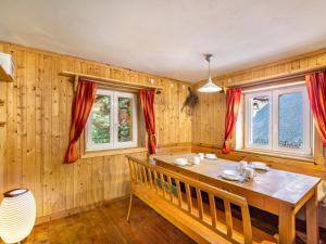 a dining room with a table and two windows at Chalet Adlerhorst-Chalet Großglockner by Interhome in Zlapp