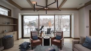 a living room with a couch and chairs and a large window at Riverlight Lodge in Steamboat Springs