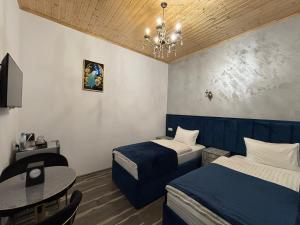 a hotel room with two beds and a table at HarMar Hotel in Goris