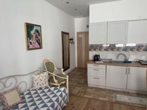 a kitchen with white cabinets and a couch in a room at Cichy Zaułek 8A in Brodnica