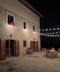 a patio with a table and chairs next to a building at Il Casale di Papà in Piemonte +7 photos