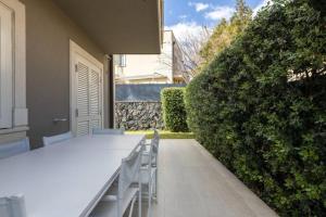 a white table and chairs in front of a hedge at Dream Villa in Izola - Pure Relaxation with Private Pool in Izola