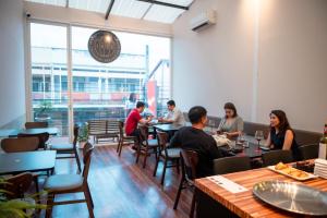 a group of people sitting at tables in a restaurant at IHOC - Phuket OldTown in Ban Lo Long